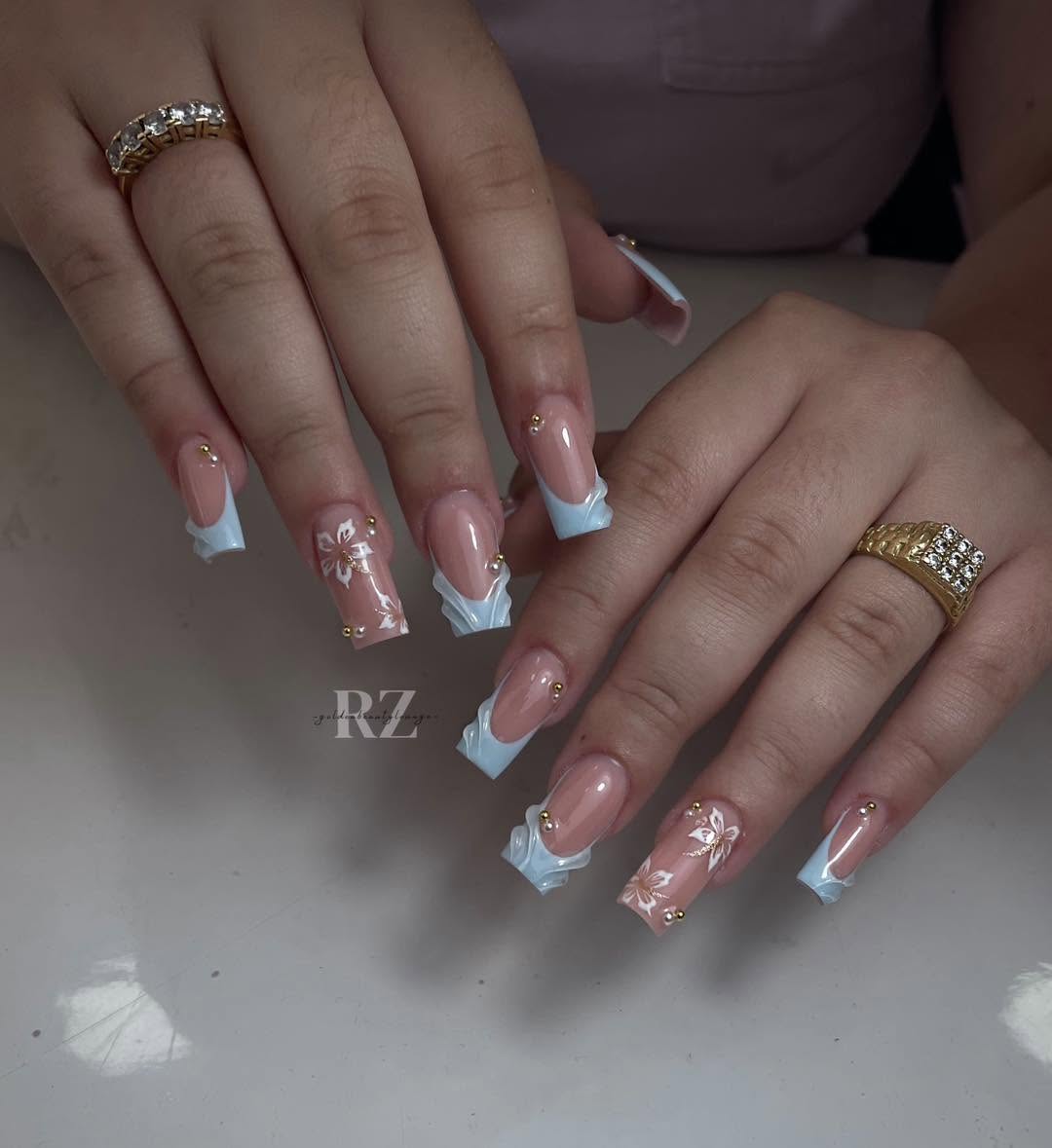 Blue French tip square nails with white floral art and gold beads
